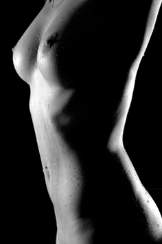 klassisches schwarz-weiss aktfoto, torso fotografiert in low-key gegenlicht