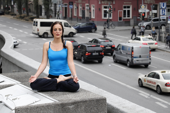 yogafoto münchen, yogini meditiert,strassenszene im hintergrund 