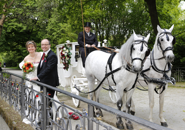 brautpaar vor hochzeitskutsche auf einer brücke im englischen garten münchen