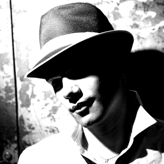 kontrastreiches Portrait junger Mann mit Hut foitograf roland schmid münchen