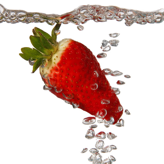 produktfotografie aus münchen, farbboto einer erdbeere mit luftblasen unter wasser